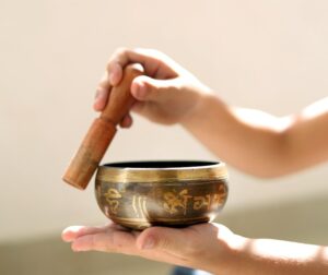 tibetan sound healing, hands holding a bowl and running a gong around it's edges, Mind Brain Institute