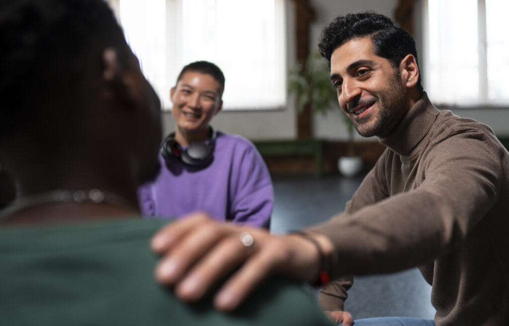 A man can be seen consoling a woman while another woman can be seen happily looking at them