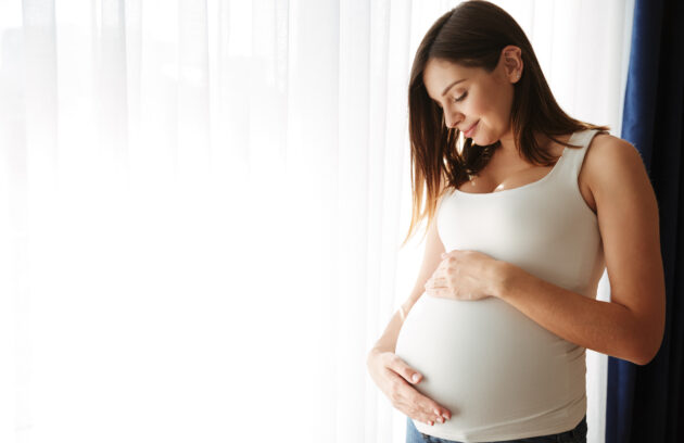 A pregnant woman can be seen caressing her belly